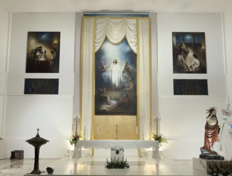 Il presbiterio della chiesa di Sant’Antonio Abate: l’altare, la pala della Trasfigurazione e i quadri alle pareti bianche