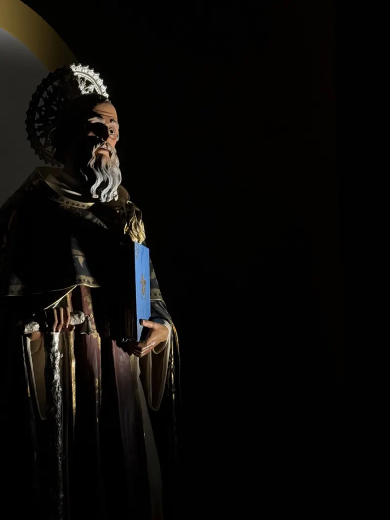 La statua di Sant’Antonio Abate in penombra, con l’aureola dorata